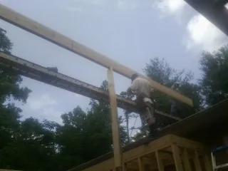 Carpenter setting a ridge beam over a new addition frame — Ice Dam Removal by Roofing Brothers in Walland