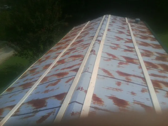 Rusted metal roof panels with new wood purlins before replacement — Storm Damage Roof Repair in Walland by Roofing Brothers