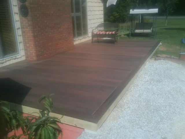 Freshly stained wood deck built against a brick home in Walland