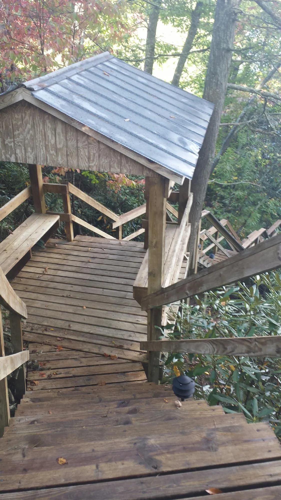 Metal roofed shelter over wooden steps on a wooded walkway — Skylight Repair & Installation work by our crew in Walland
