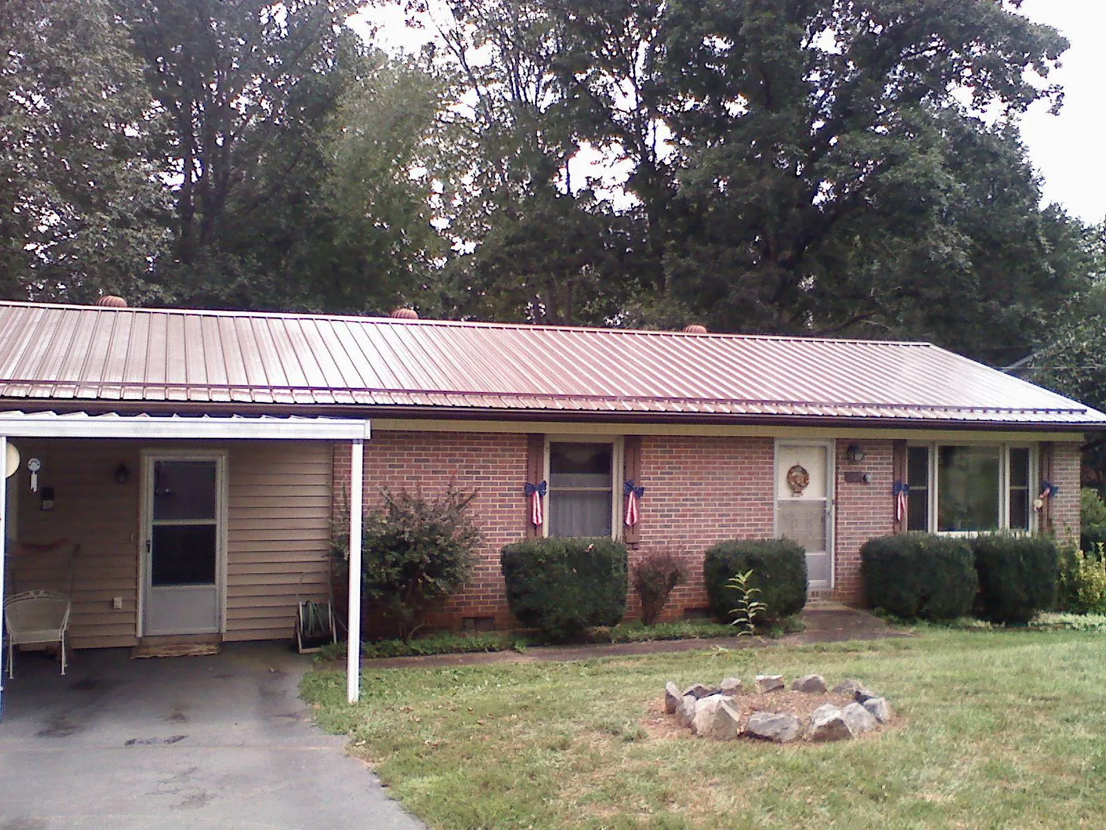 Bronze metal roof and carport on a brick ranch home — Roof Repair work by our crew in Walland
